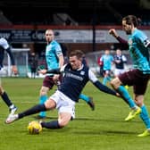 Dundee's Lee Ashcroft slides in on Hearts' Peter Haring at Dens Park.