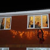 People wave from inside a care home during the Christmas period (Picture: Michael Gillen)