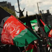 People waving Afghan flags during a protest. Picture: Niall Carson/PA Wire