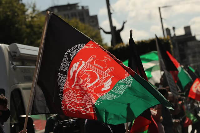 People waving Afghan flags during a protest. Picture: Niall Carson/PA Wire