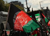 People waving Afghan flags during a protest. Picture: Niall Carson/PA Wire