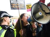 A demonstrator speaks in a loud hailer as she protests against the arrival of the Tory leadership contenders to the Perth hustings on 16 August