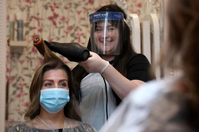 Salon manager Gemma Inglis works on the hair of Shireen Inglis at the Lunatic Fringe in Glasgow as hairdressers reopen to customers