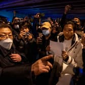 A government official at left speaks to participants in a protest against China's strict zero COVID measures in Beijing, China.