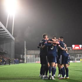 Scotland's forward Lyndon Dykes is mobbed by team-mates after scoring the winning goal.