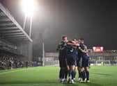 Scotland's forward Lyndon Dykes is mobbed by team-mates after scoring the winning goal.