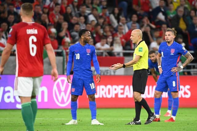 Turkish referee Cuneyt Cakir (2nd R) and England's forward Raheem Sterling debate during the FIFA World Cup Qatar 2022 qualification Group I football match between Hungary and England, at the Puskas Arena in Budapest on September 2, 2021. (Photo by ATTILA KISBENEDEK/AFP via Getty Images)