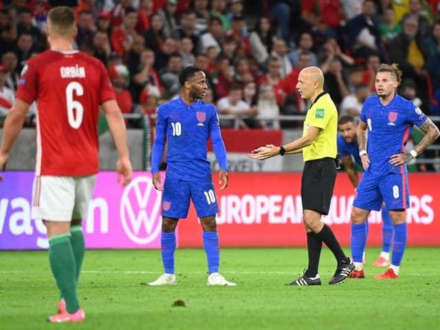Turkish referee Cuneyt Cakir (2nd R) and England's forward Raheem Sterling debate during the FIFA World Cup Qatar 2022 qualification Group I football match between Hungary and England, at the Puskas Arena in Budapest on September 2, 2021. (Photo by ATTILA KISBENEDEK/AFP via Getty Images)