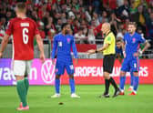 Turkish referee Cuneyt Cakir (2nd R) and England's forward Raheem Sterling debate during the FIFA World Cup Qatar 2022 qualification Group I football match between Hungary and England, at the Puskas Arena in Budapest on September 2, 2021. (Photo by ATTILA KISBENEDEK/AFP via Getty Images)
