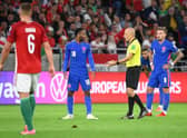 Turkish referee Cuneyt Cakir (2nd R) and England's forward Raheem Sterling debate during the FIFA World Cup Qatar 2022 qualification Group I football match between Hungary and England, at the Puskas Arena in Budapest on September 2, 2021. (Photo by ATTILA KISBENEDEK/AFP via Getty Images)