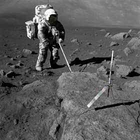 Geologist-Astronaut Harrison Schmitt, Apollo 17 lunar module pilot, uses an adjustable sampling scoop to retrieve lunar samples during the second extravehicular activity (EVA-2), at Station 5 at the Taurus- Littrow landing site.