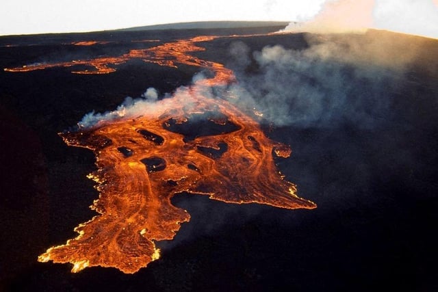 This aerial image released by the US Geological Survey (USGS) courtesy of the National Weather Service, shows the lava in the summit caldera of Mauna Loa in Hawaii, which is erupting for the first time in nearly 40 years. - Hawaii's Mauna Loa, the largest active volcano in the world, has erupted for the first time in nearly 40 years, US authorities said, as emergency crews went on alert early Monday. Photo via Getty