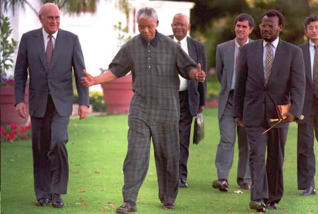 FW de Klerk, left, walks with Nelson Mandela, centre, and Zulu leader Mangosuthu Buthelezi in 1995 (Picture: Guy Tillim/AFP via Getty Images)