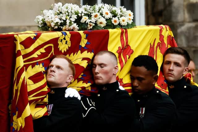 Pallbearers carrying the coffin of Queen Elizabeth II, draped with the Royal Standard of Scotland, as it arrives at Holyroodhouse, Edinburgh where it will lie in rest for a day. Picture date: Sunday September 11, 2022.