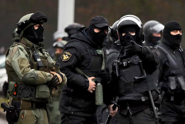 Law enforcement officers patrol a street as opposition supporters rally to protest against police violence and Belarus presidential election results in Minsk