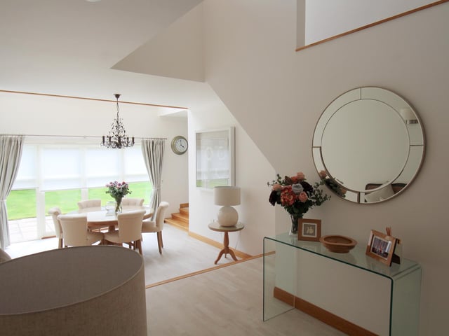 Interior: Accommodation includes a formal lounge, double-height dining space and open-plan family room, plus kitchen and diner. Two bedrooms upstairs are ensuite, and there is a study/office.