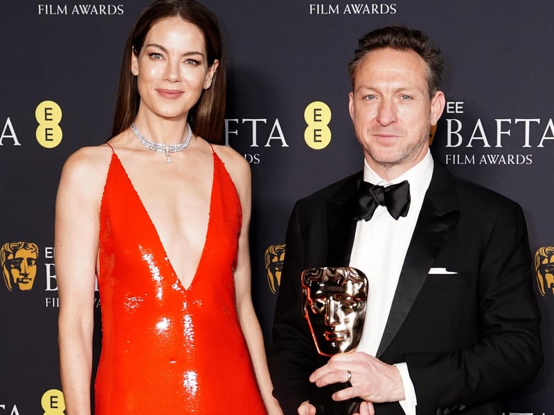 Michelle Monaghan presents Lol Crawley with the Best Cinematography award for The Brutalist during the 78th British Academy Film Awards