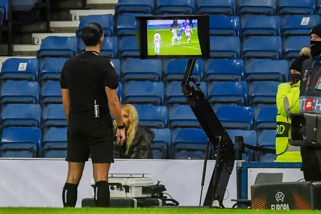Referee Serdar Gözübüyük reviews the VAR monitor for a potential penalty for a foul on Rangers' Ryan Kent during a UEFA Europa League match between Rangers and Red Star Belgrade at Ibrox.