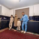 Ammaduddin Sidiqi with three of his children in their new kitchen at Calton Village