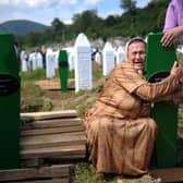 A Bosnian woman cries over the newly dug graves of her two sons at a cemetery near Srebrenica in 2010, 15 years after nearly 8,000 Muslims were murdered (Picture: Dimitar Dilkoff/AFP via Getty Images)