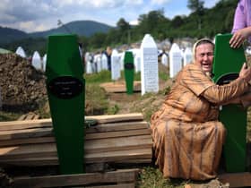 A Bosnian woman cries over the newly dug graves of her two sons at a cemetery near Srebrenica in 2010, 15 years after nearly 8,000 Muslims were murdered (Picture: Dimitar Dilkoff/AFP via Getty Images)