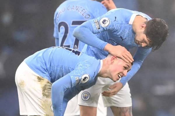 Phil Foden of Manchester City is congratulated by teammate John Stones after scoring on January 13