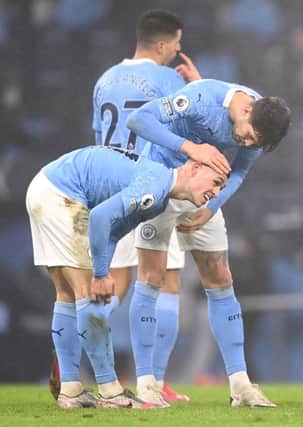 Phil Foden of Manchester City is congratulated by teammate John Stones after scoring on January 13