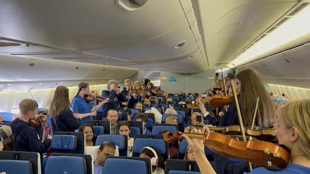 Members of the Ayrshire Fiddle Orchestra playing tunes to passengers on their outbound KLM flight to Atlanta (pic: Ayrshire Fiddle Orchestra)