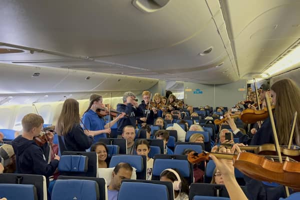 Members of the Ayrshire Fiddle Orchestra playing tunes to passengers on their outbound KLM flight to Atlanta (pic: Ayrshire Fiddle Orchestra)