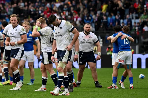 Scotland's players react as Italy's players celebrate after winning the Six Nations match. (Photo by Alberto PIZZOLI / AFP) (Photo by ALBERTO PIZZOLI/AFP via Getty Images)