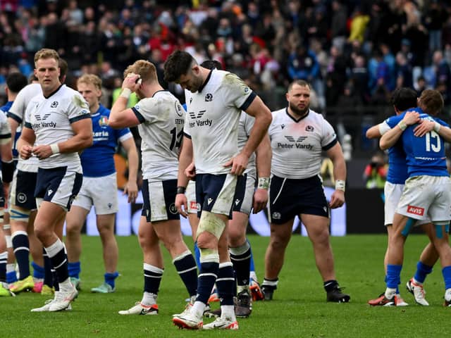 Scotland's players react as Italy's players celebrate after winning the Six Nations match. (Photo by Alberto PIZZOLI / AFP) (Photo by ALBERTO PIZZOLI/AFP via Getty Images)