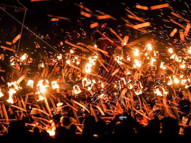 Participants take part in the Up Helly Aa festival parade through the streets of Lerwick, Shetland Islands on January 31, 2023. - Up Helly Aa celebrates the influence of the Scandinavian Vikings in the Shetland Islands and culminates with up to 1,000 'guizers' (men in costume) throwing flaming torches into their Viking longboat and setting it alight later in the evening. (Photo by Andy Buchanan / AFP)