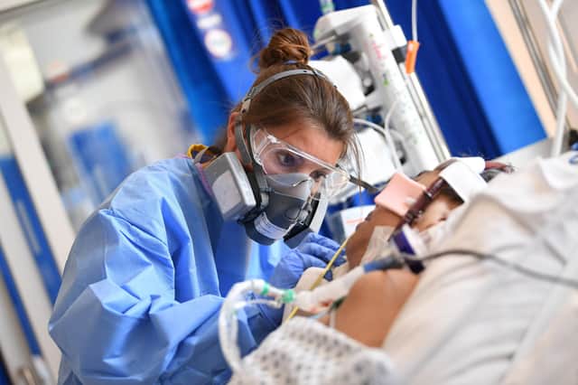 An NHS worker cares for a patient with Covid in intensive care (Picture: Neil Hall/pool/AFP via Getty Images)