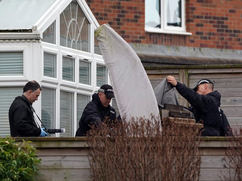 A photographer and officers from Police Scotland at the home of former chief executive of the SNP Peter Murrell, in Uddingston, Glasgow, after he was arrested in connection with the ongoing investigation into the funding and finances of the party.