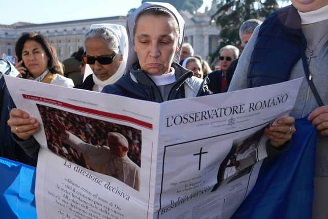 A nun reads the Vatican newspaper L'Osservatore Romano carrying the news of the death of Pope Emeritus Benedict XVI
