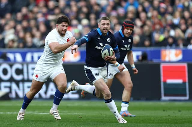 Scotland's scrum-half Finn Russell (C) runs with the ball chased by France's hooker Julien Marchand (L) during the Six Nations clash in Paris.