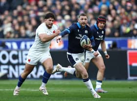 Scotland's scrum-half Finn Russell (C) runs with the ball chased by France's hooker Julien Marchand (L) during the Six Nations clash in Paris.