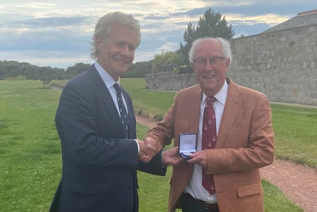 Nevin McGhee, right, receives the Murdoch Medal, awarded by the British Golf Collectors Society (BGCS), from previous winner Alastair Johnston in Troon.