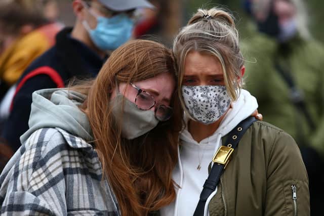 Two women embrace as they pay their respects on Clapham Common, where floral tributes were placed in memory of Sarah Everard after her death (Picture: Hollie Adams/Getty Images)