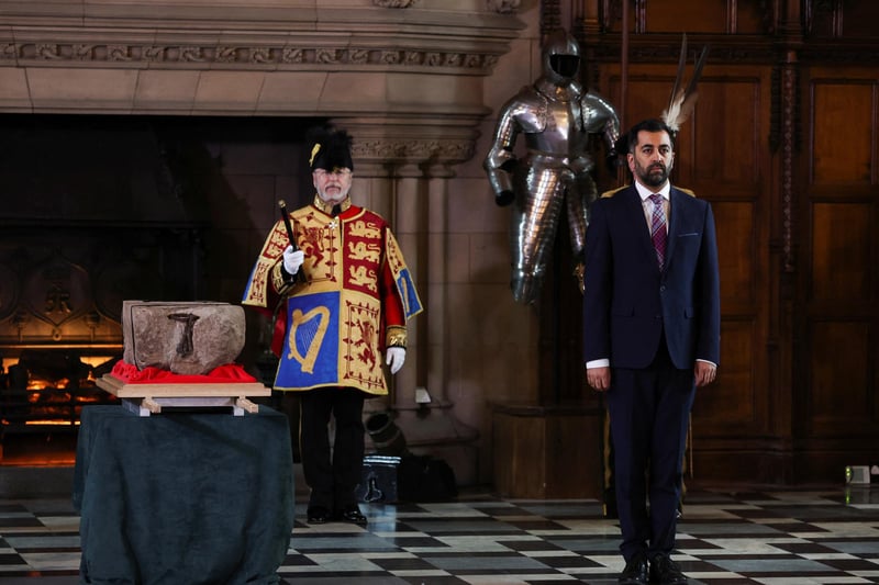 First Minister Humza Yousaf stands beside the Stone of Destiny, which is also known as the Stone of Scone