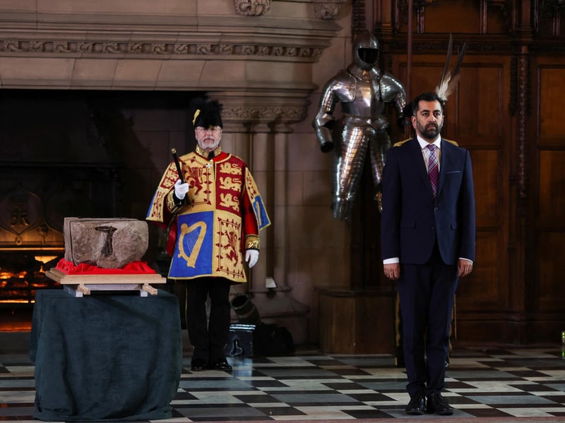 First Minister Humza Yousaf stands beside the Stone of Destiny, which is also known as the Stone of Scone