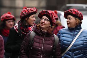 Tourists wearing tartan hats walk along the Royal Mile in Edinburgh. PA Photo. Picture: Andrew Milligan/PA Wire