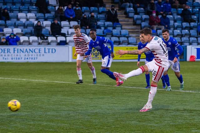 Joshua Mullin (centre) misses a penalty during a cinch Championship match between Queen of the South and Hamilton at Palmerston Park, on January 02, 2022, in Dumfries, Scotland.