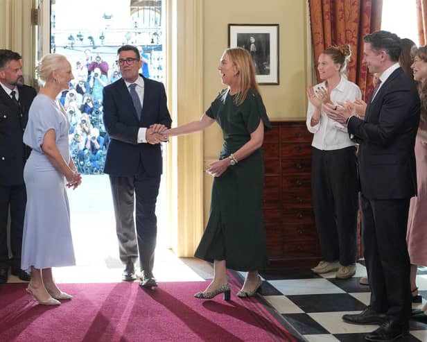 Staff applaud as new Prime Minister Andy Burnham and his wife Marie-France van Heel walk into 10 Downing Street (Picture: Kin Cheung/ POOL/AFP via Getty)