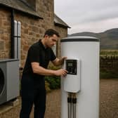 A technician installs modern heating technology in Scotland, representing the £33 billion clean heat transition opportunity that English firms like FlexiHeat UK are targeting through digital marketing partnerships as Scotland accelerates its move toward renewable heating solutions.
