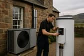A technician installs modern heating technology in Scotland, representing the £33 billion clean heat transition opportunity that English firms like FlexiHeat UK are targeting through digital marketing partnerships as Scotland accelerates its move toward renewable heating solutions.