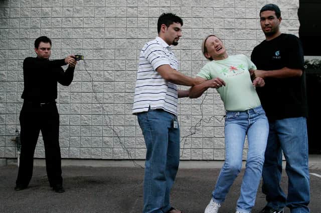 A Taser International employee, Evelina Self, is shot with the company's X26 model by company president Tom Smith (Picture: Jeff Topping/Getty Images)