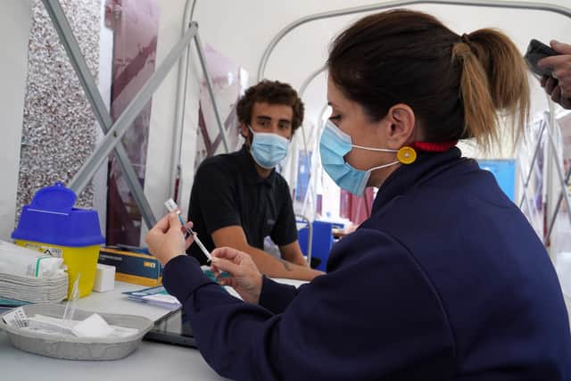 Vaccinator Suzanne Pozzo gives a vaccine to Omar Khalifa in a pop up tent at a drop in clinic outside Stenhousemuir Football Ground. Picture: PA Media