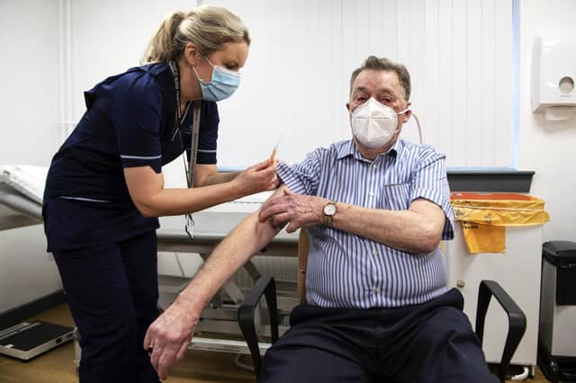 Advanced nurse practitioner Justine Williams prepares to administer a dose of the AstraZeneca/Oxford Covid-19 vaccine to 82-year-old James Sha, at the Lochee Health Centre on January 4, 2021 in Dundee, Scotland. Photo by Andy Buchanan - WPA Pool/Getty Images