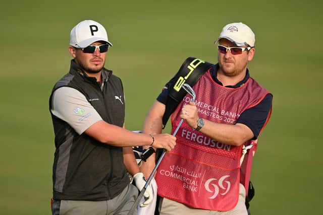 Ewen Ferguson hands a club to of caddie and fellow Scot Stephen Neilson during the first round of the Commercial Bank Qatar Masters at Doha Golf Club. Picture: Stuart Franklin/Getty Images.